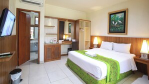 A hotel room with a bed, a desk, a mirror, a television, and a painting on the wall.