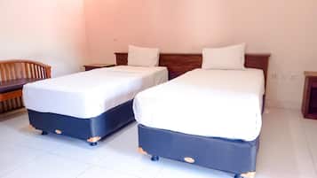 Una habitación de hotel con dos camas individuales, un banco de madera y una mesita de noche.