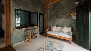 A cozy room with a wooden bench, a large window, and a patterned rug. - Mag Canggu Bali (Canggu)