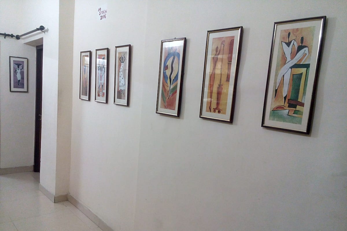 A hallway with six framed artworks on the wall.