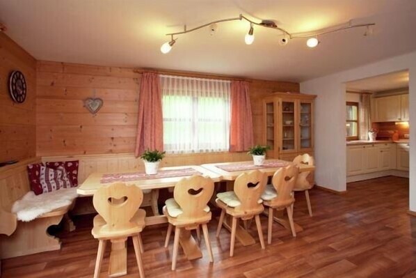 A cozy wooden room with a dining table, chairs, and a bench.