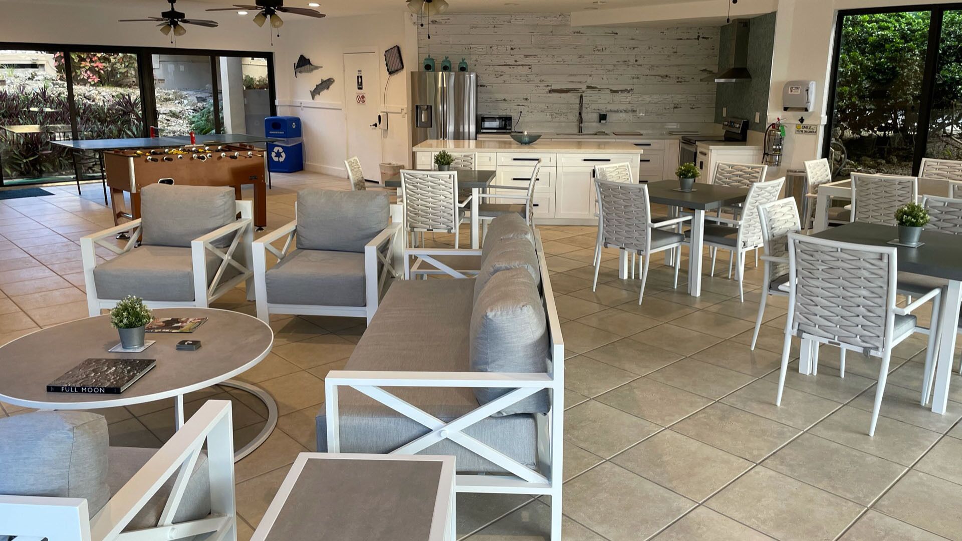 Un interior moderno con zona de comedor, sofás y cocina con salpicadero de piedra.