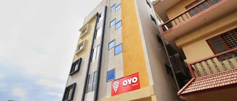 A multi-story building with a sign for "Oyo Rooms" on the facade.