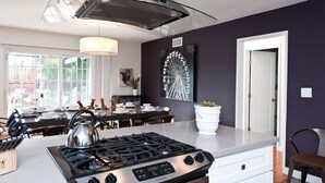 A modern kitchen with a gas stove, a large island, and a dining area with a table and chairs. - LAST MINUTE SPECIAL! WALK TO DISNEY & CONVENTION CENTER! Private heatedpool (Anaheim)