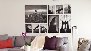 A living room with a grey sofa, a coffee table, and a wall decorated with black and white cityscape photographs. - LAST MINUTE SPECIAL! WALK TO DISNEY & CONVENTION CENTER! Private heatedpool (Anaheim)