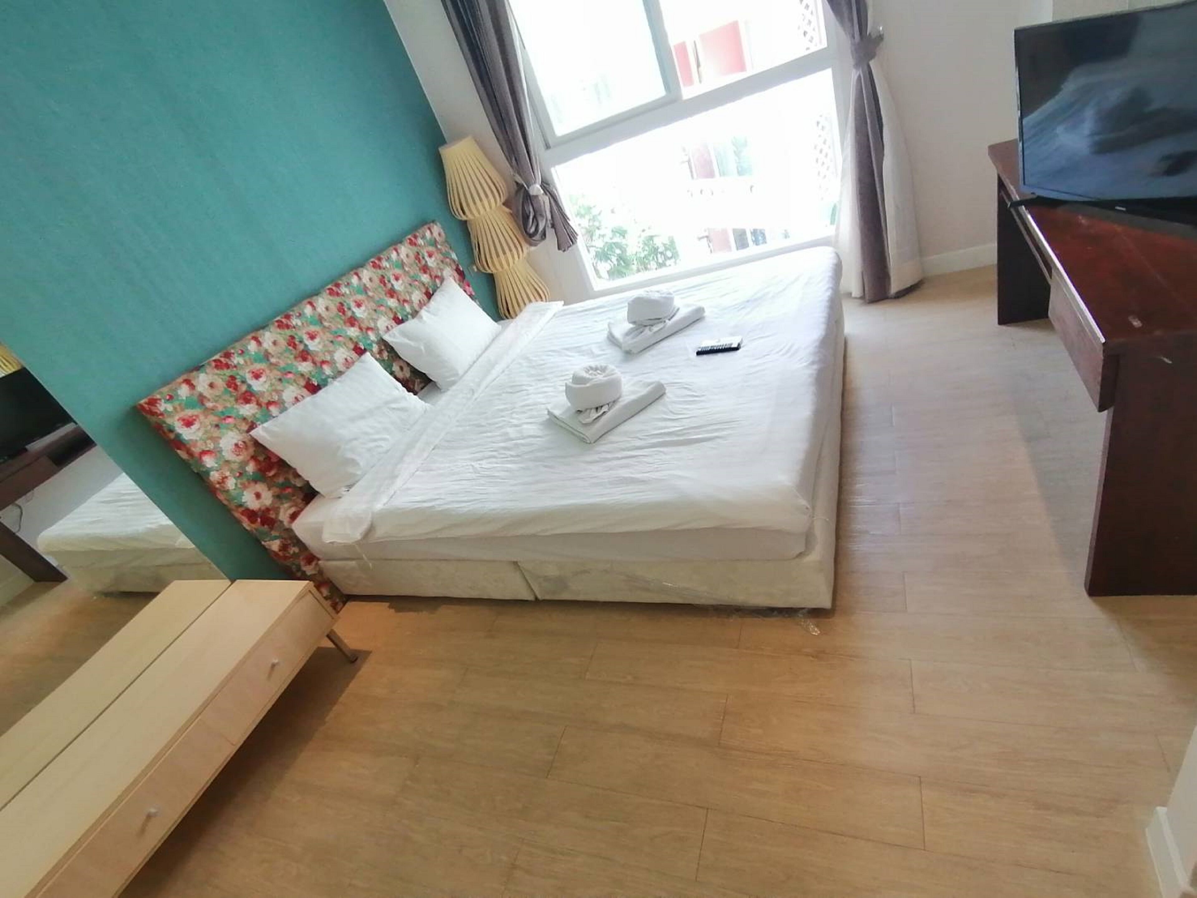 Une chambre à coucher avec un lit, une télévision et un plancher en bois.