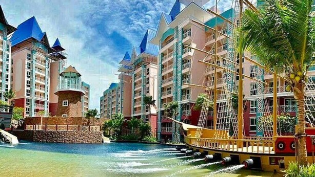 Un complexe hôtelier comprenant plusieurs immeubles de grande hauteur, un espace aquatique et un bateau.