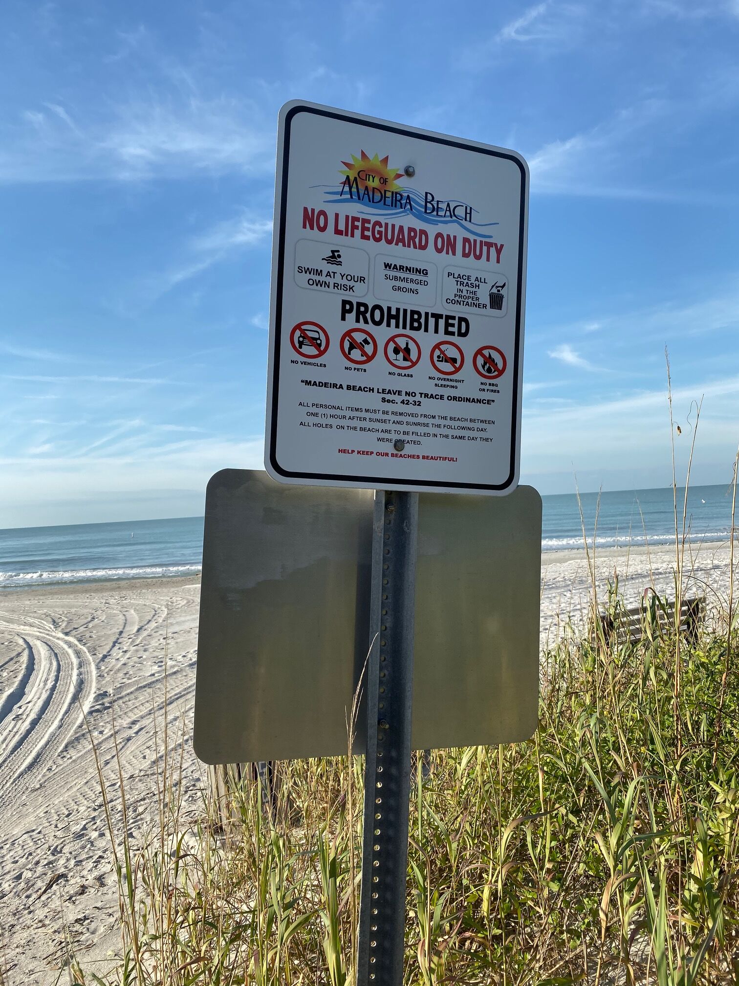 Um letreiro de praia com proibições e avisos para visitantes.