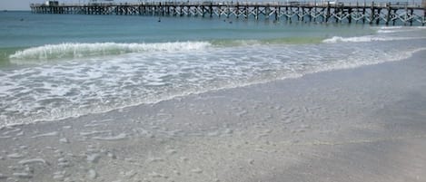 Walk along the pier and enjoy the serene beach atmosphere.