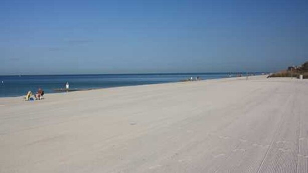 A wide, sandy beach with a clear blue sky and calm sea. - PRIME STUDIO SAVE. UPSCALE BEACHFRONTS. SUN,SURF&SAND, TOWN 2 BLOCKS, PKG,CHAIRS (Madeira Beach)