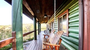 A wooden porch with two rocking chairs and a ceiling fan. - Family Favorite! no curves, pets , theater, , yard , fire pit , min to strip  (SEVIERVILLE)