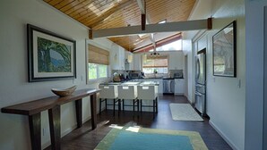 A modern kitchen with white cabinetry, a central island, and a wooden ceiling. - Hale Waiaha Spacious Holualoa Home  (Holualoa)