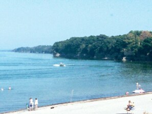 A beach with a sandy shore, a few people, and a boat in the water. - Surrounded by orchards & vineyards, we are in the heart of wine country (Westfield)