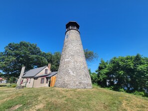 A stone lighthouse with a wooden door and a small house nearby. - Surrounded by orchards & vineyards, we are in the heart of wine country (Westfield)