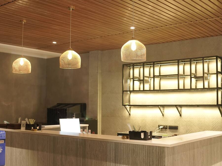 A reception desk with a wooden ceiling, pendant lighting, and a modern design.