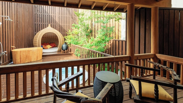 A wooden deck with a hot tub, a hanging chair, and a wooden bench. - Tsuruya (Aso)
