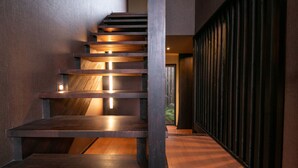 A modern staircase with wooden steps and metal railings, leading to an upper level. - Tsuruya (Aso)
