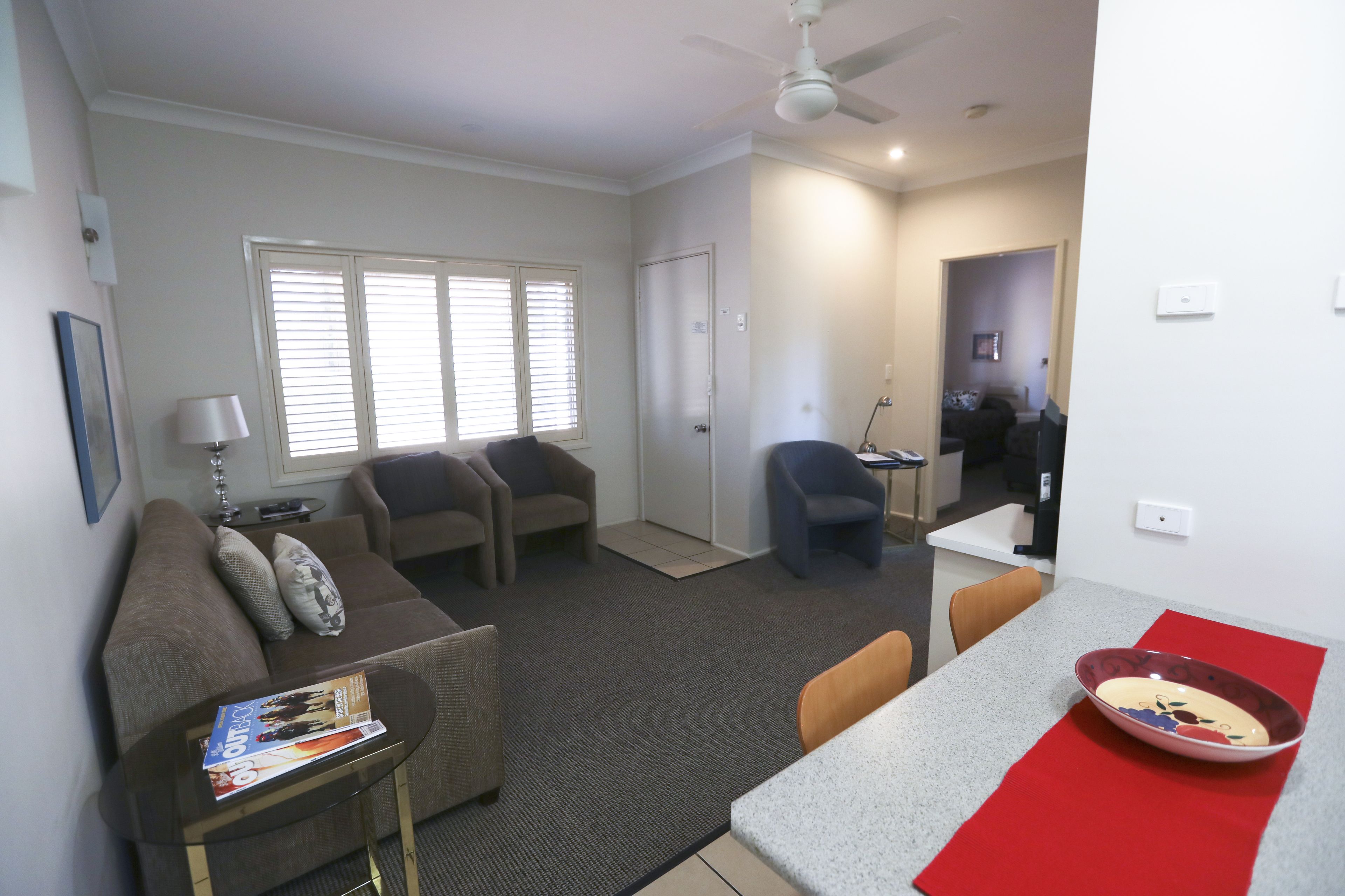 A living room with a sofa, armchairs, a coffee table, and a dining area with a table and chairs.