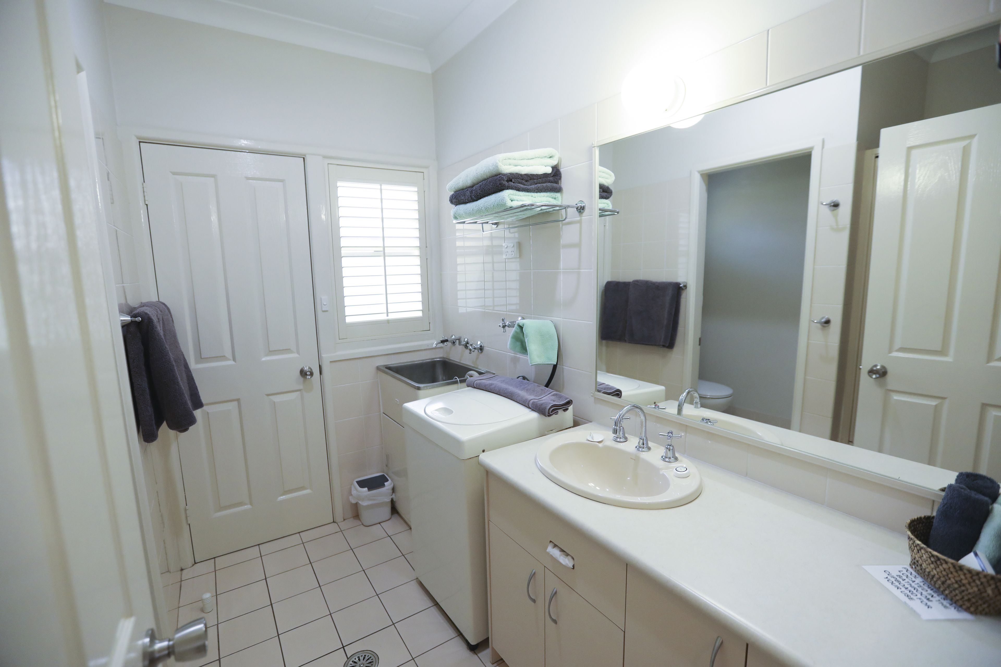A bathroom with a sink, mirror, and two doors.