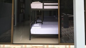Ein modernes Zimmer mit Etagenbetten, einer Schiebetür und einem kleinen Balkon.
