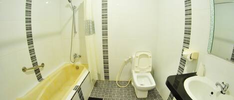 A bathroom with a bathtub, toilet, and sink.