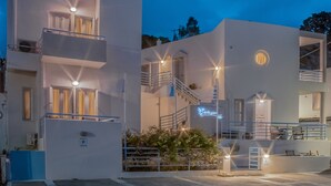 Un edificio moderno de varios pisos con balcones, escaleras y un letrero de neón.