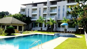 A modern hotel with a swimming pool, a covered area, and a well-maintained garden. - Hotel Sadhana Executive (Dapoli)