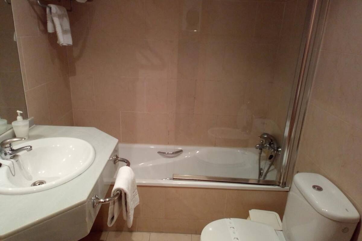 A bathroom with a sink, bathtub, and toilet.