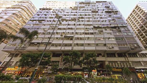 A high-rise building with multiple balconies and air conditioning units. - KG Garden Guest House (Kowloon)