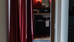 A hallway leading to a bathroom with a sink and mirror. - B&B Scheldekant (Oudenaarde)