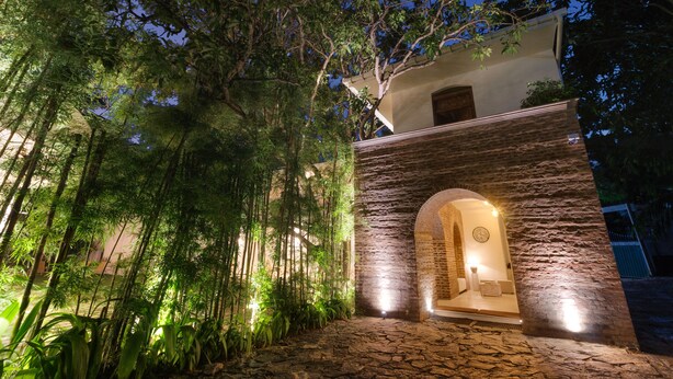 A stone building with an arched entrance and a small porch area. - Epic Unawatuna (Unawatuna)