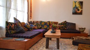 A cozy living room with a sofa set, a wooden coffee table, and patterned rugs. - Villa Poa (Arusha)