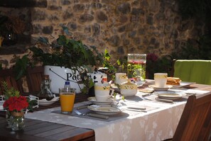 A table set for breakfast with plates, cups, and a pitcher of orange juice.