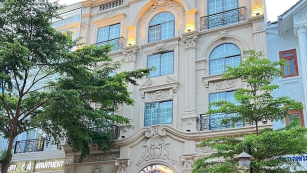 Ein Gebäude mit einem Schild, auf dem "Royal Crown" und "60" stehen, das ein Hotel kennzeichnet.