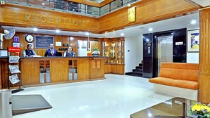 Una zona de recepción con un mostrador de madera, un reloj y un letrero que dice "RECEPTION".