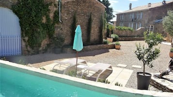 Una piscina al aire libre de temporada, sombrillas