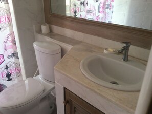 A bathroom with a toilet, sink, and mirror. - Baan Somprasong Apartment - Na Jomtien (Sattahip)