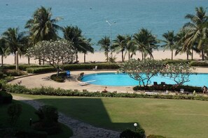 A pool surrounded by palm trees and a beach. - Baan Somprasong Apartment - Na Jomtien (Sattahip)