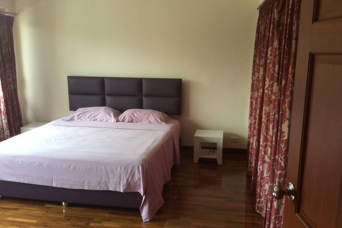 Une chambre à coucher avec un lit, une table de chevet et une porte.