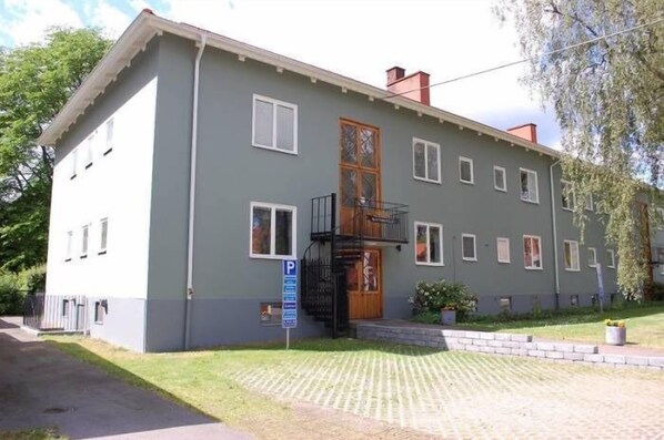 A two-story building with a grey facade, a wooden door, and a small balcony. - Slottshotellet Annex (Kalmar)