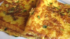 A close-up of a dish with a golden-brown crust, likely a savory baked item with herbs. - Blue Marine Resort (Calangute)