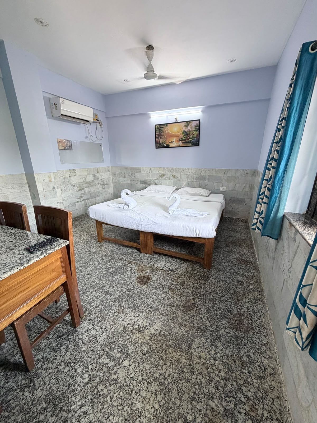 Une chambre avec un lit, un bureau et un ventilateur de plafond.