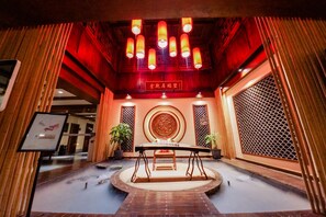 A traditional Chinese room with a central table, red lanterns, and wooden decor. - CQJ Lestay Hotel (Hangzhou)