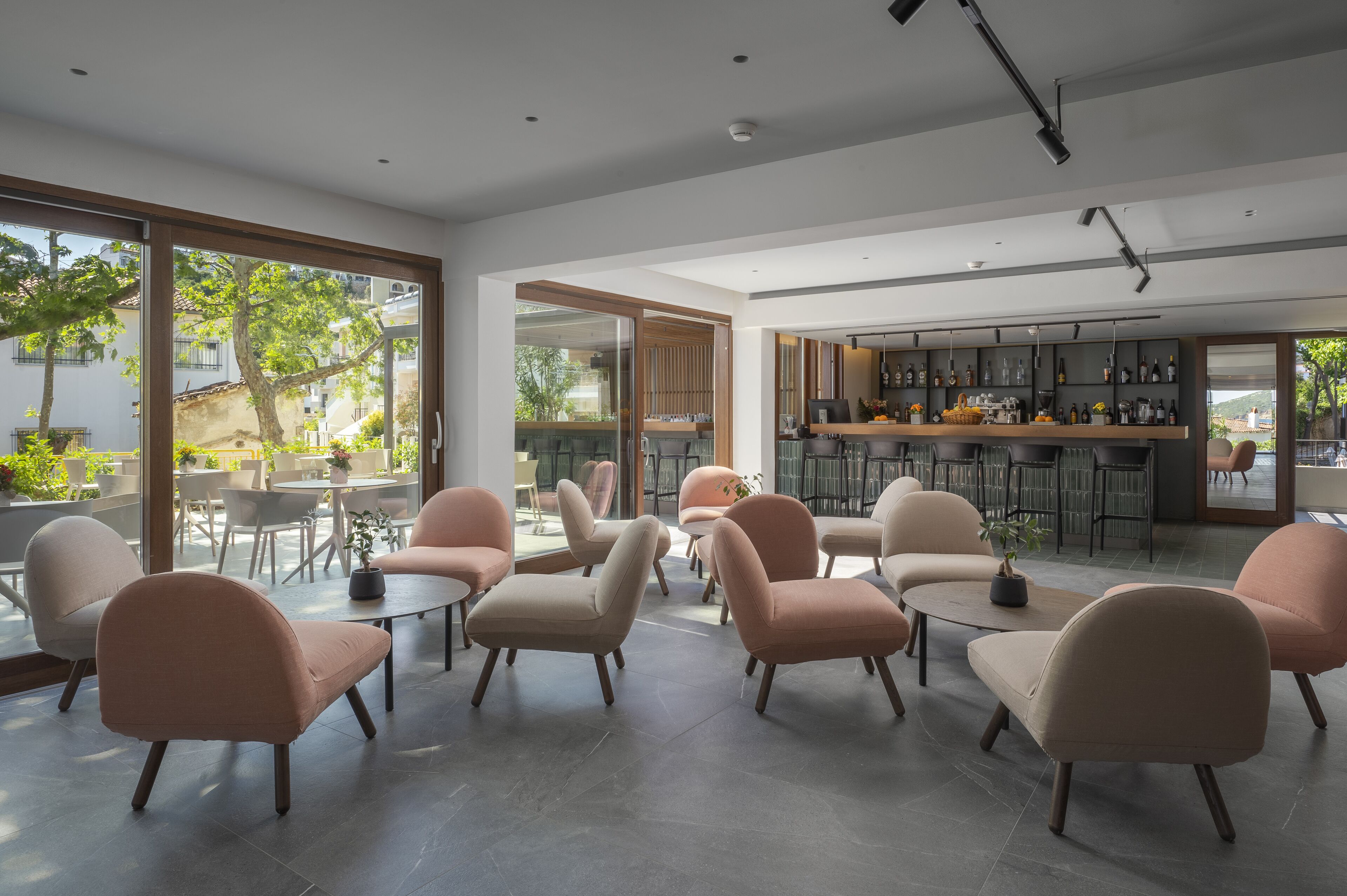 A modern interior with seating areas, a bar, and large windows.