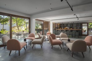 A modern interior with seating areas, a bar, and large windows.