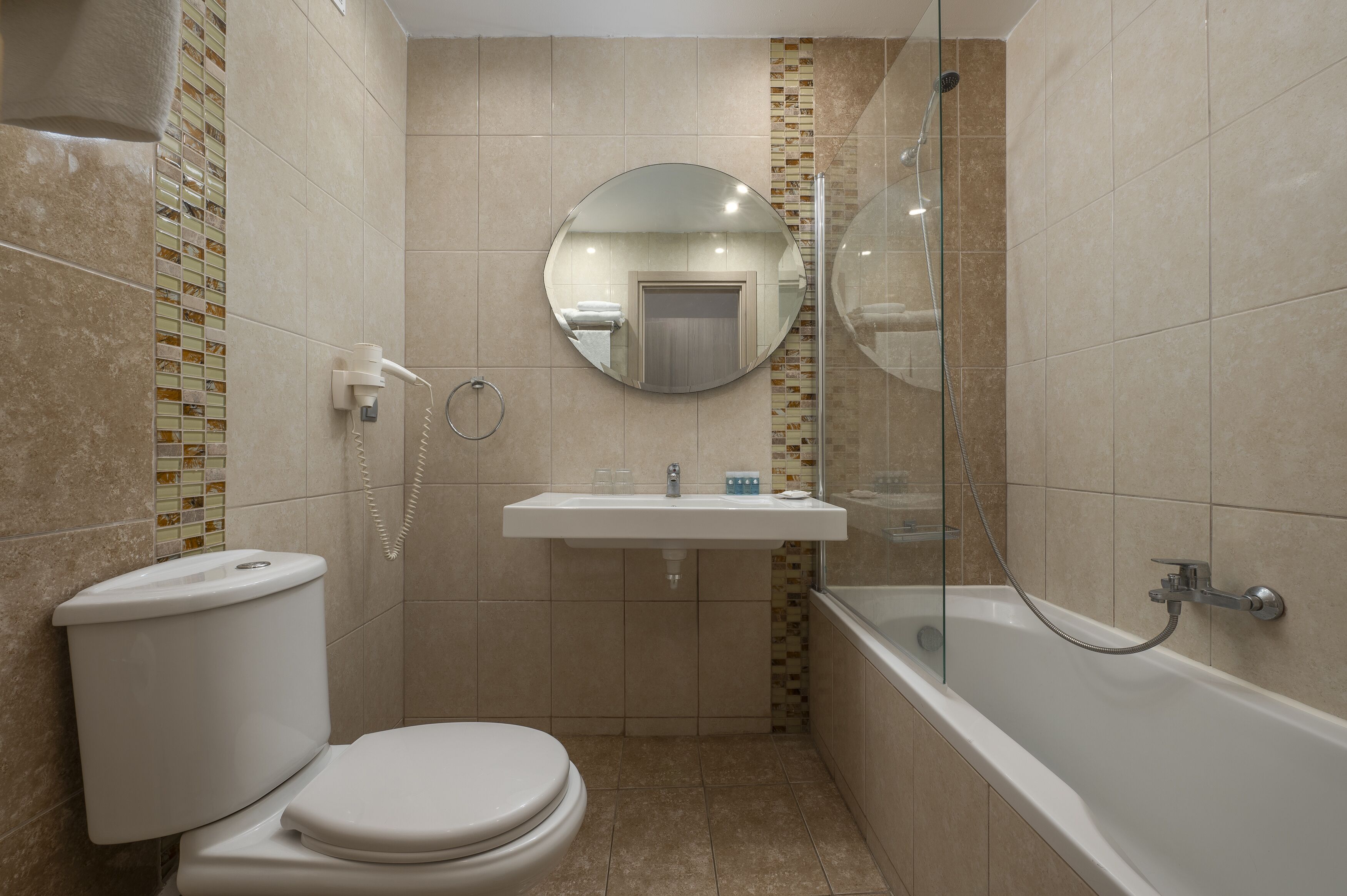 Ein kleines Badezimmer mit Toilette, Waschbecken und Badewanne.