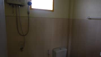Un baño pequeño y sencillo con inodoro, lavabo y ducha.