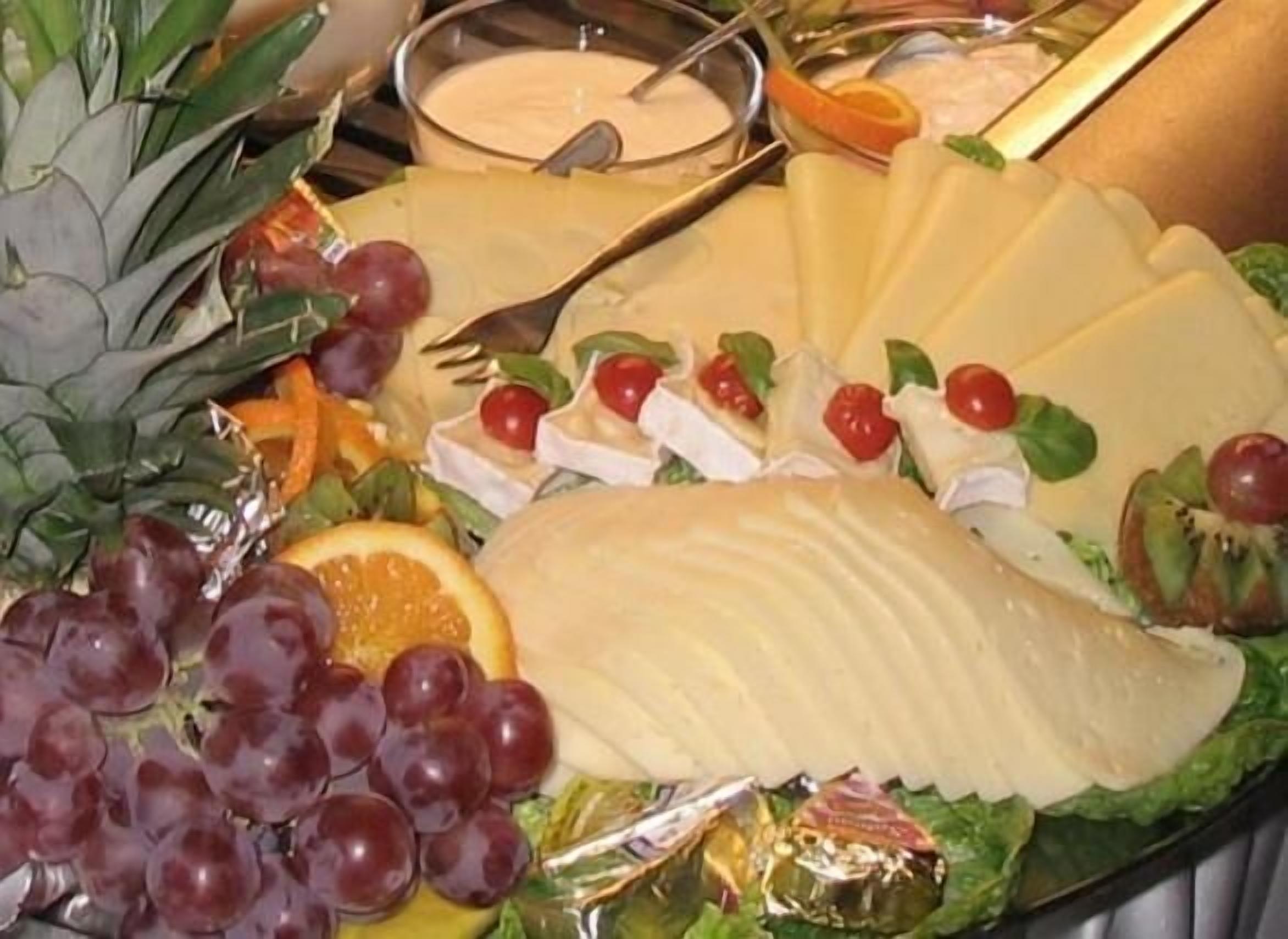 En osteplatter med forskellige oste, druer og frugter.