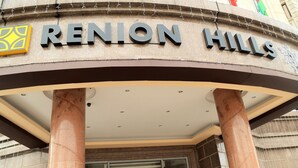 The entrance to Renion Hills with a prominent sign and large columns. - Renion Hills Hotel (Almaty)