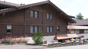 Un bâtiment en bois doté de nombreuses fenêtres et d’un balcon.
